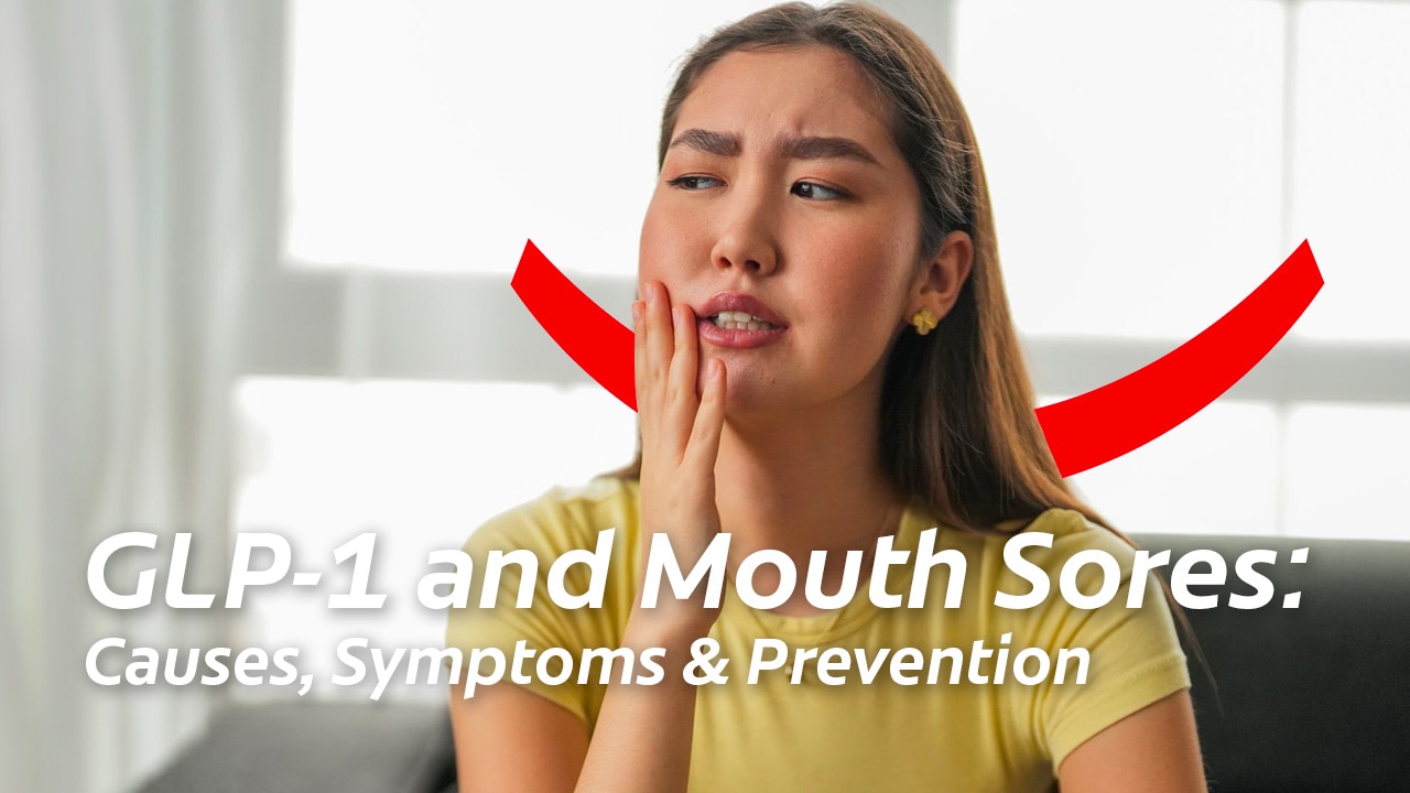 A blonde woman in a yellow t-shirt holding her hand to the side of her face and looking uncomfortable due to GLP-1 mouth sores. 