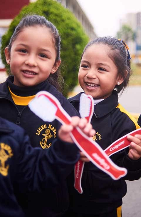 Niñas con cepillos de dientes Colgate