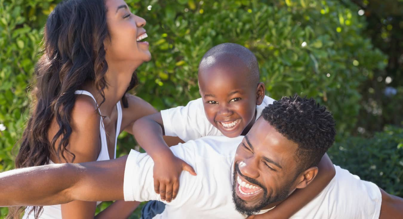 a father and his whife and child smiling brightly laying 