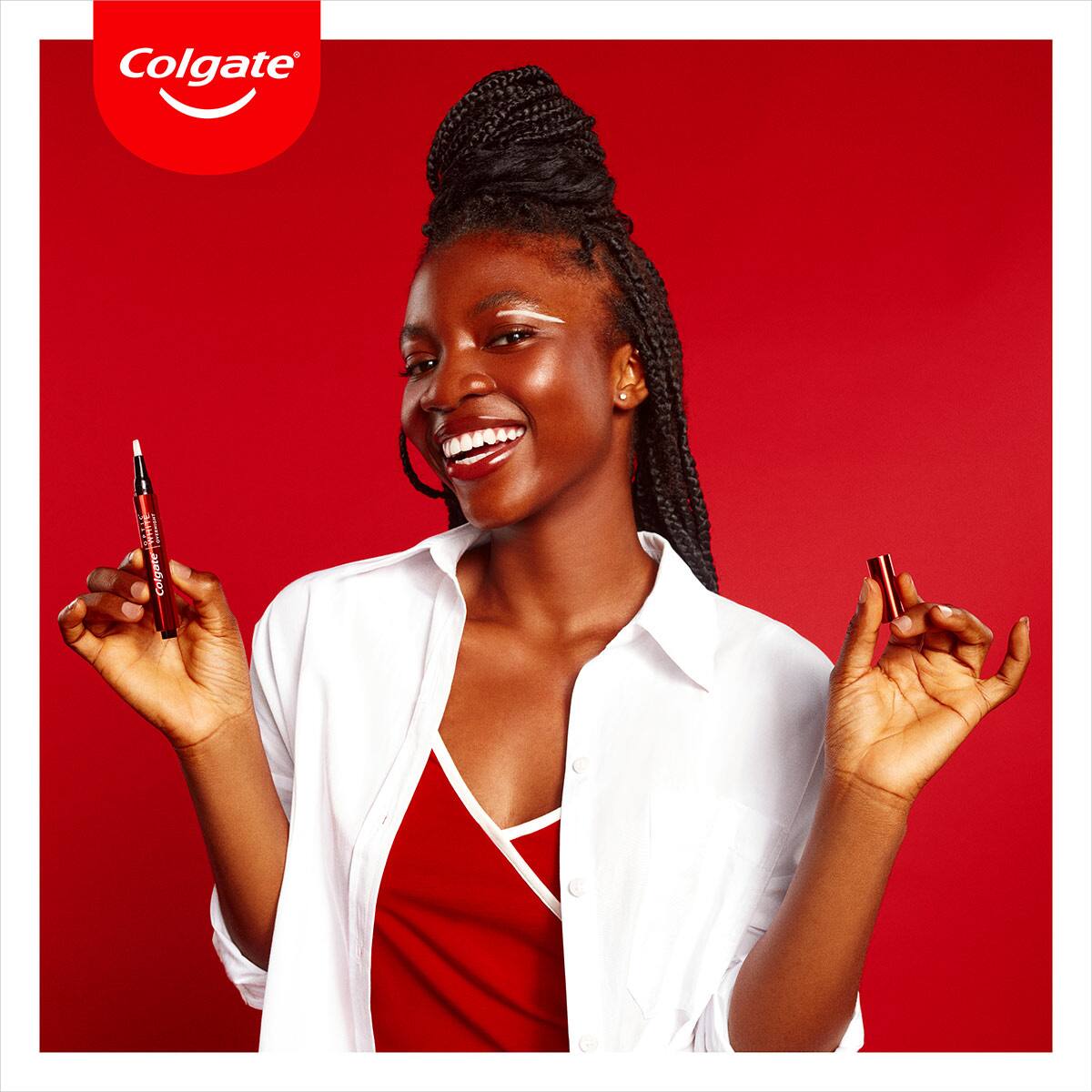African woman smiling while holding Optic White overnight pen