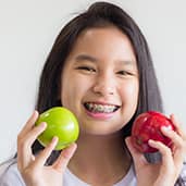 girl smilling with apples on the hand
