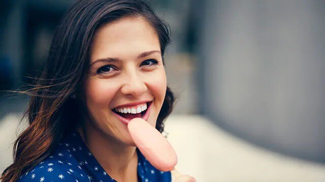 woman eating ice cream after sensitive teeth treatments