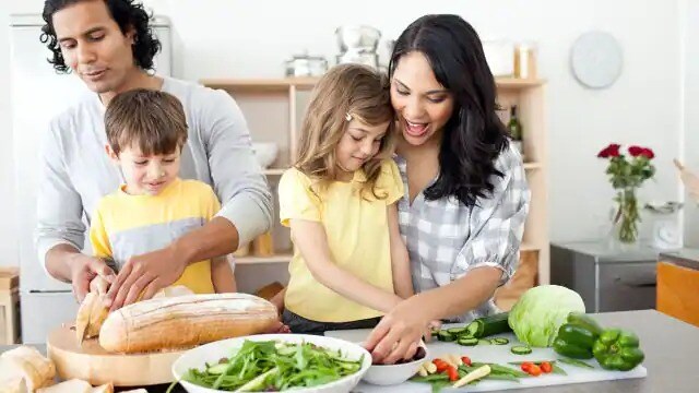 mom helping child cook in kitchen