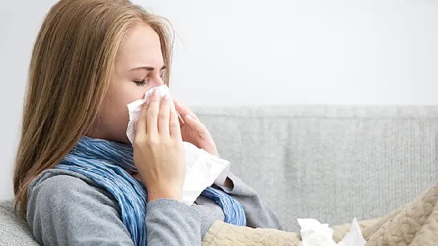 woman sneezing due to illness