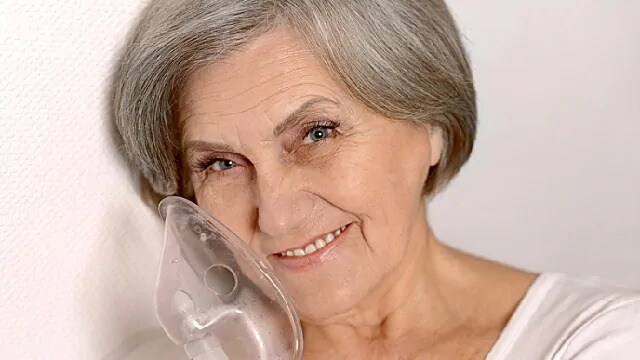 woman with oxygen mask smiling