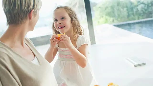 young girl eating a peach