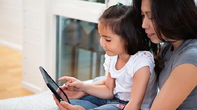 mother and child playing a dental game on tablet