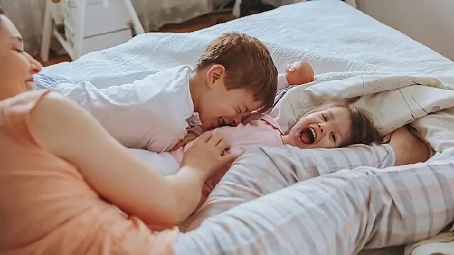 Two children laughing while being tickled