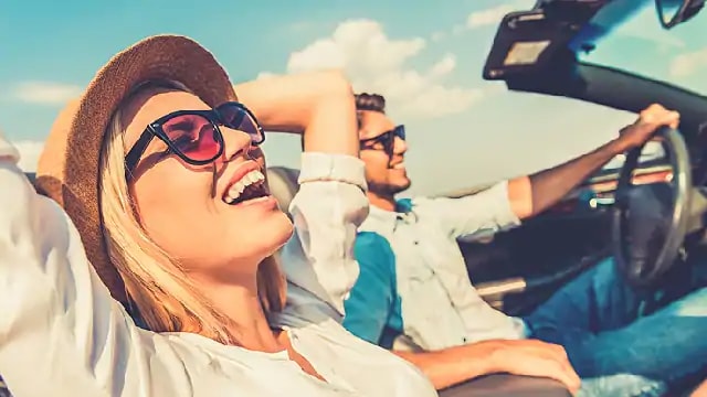 Smiling couple sitting in a convertible