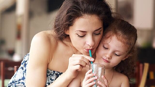 mother and daughter drinking water to promote good oral health