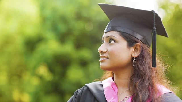 a female college student is graduating and smiling with whiter teeth after stain removal	