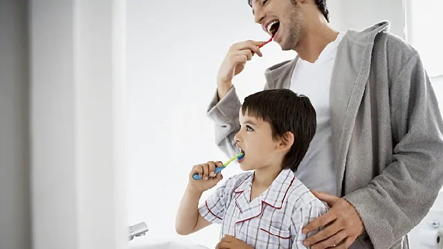person using disclosing tablets to better clean teeth