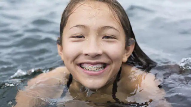 kid with braces to correct teeth