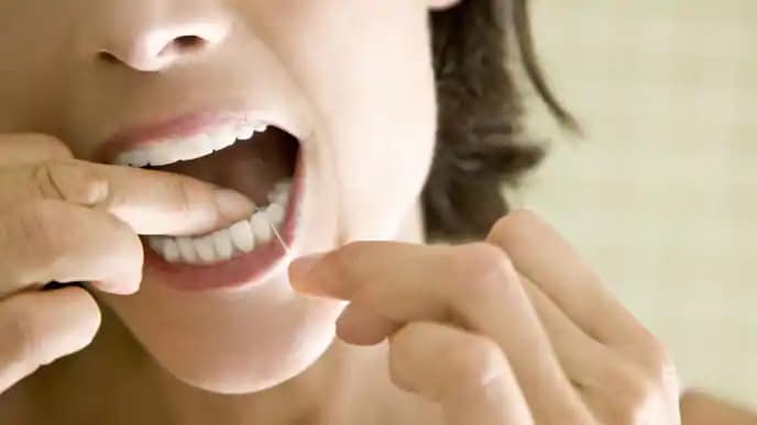 woman cleaning teeth to help with smoking side effects
