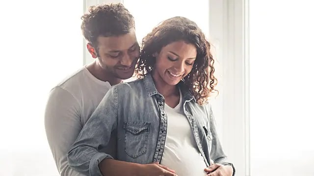 pregnant woman smiling with her partner