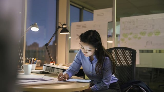 Businesswoman with digital tablet working late in an office