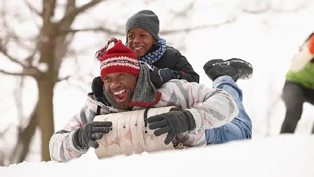 father and son riding a sled
