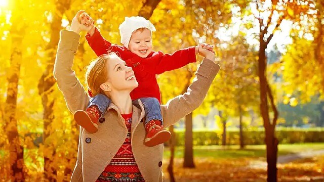 mother carrying her child through the park