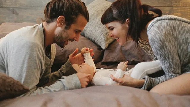 parents playing with their newborn baby