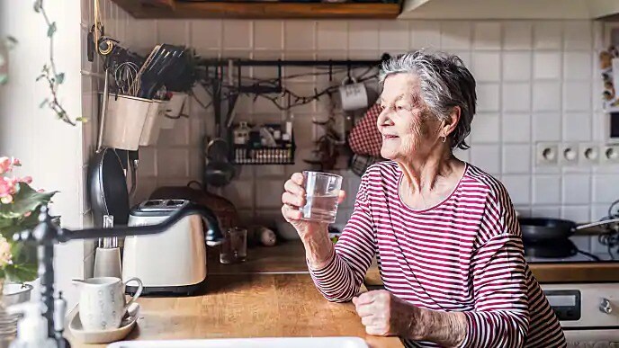 woman drinking water to help with mouth sore