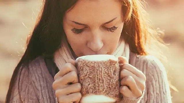 woman drinking tea to help with sore throat