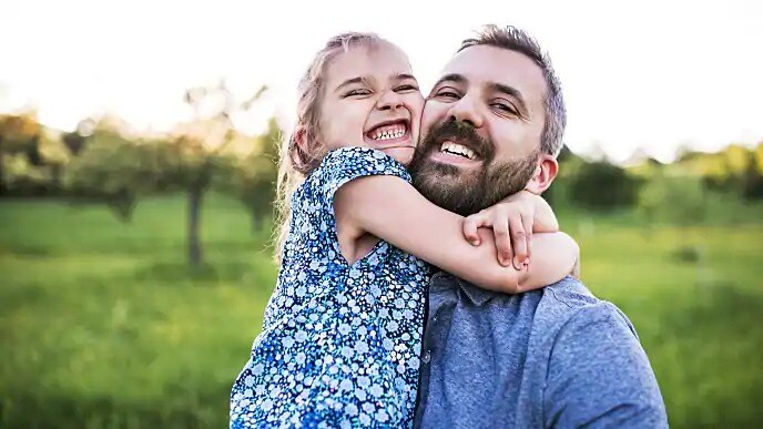 father smiling with daughter