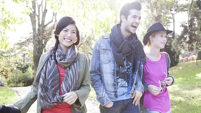 friends laughing while walking through the park