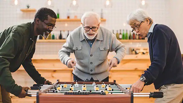 man with dentures playing foosball