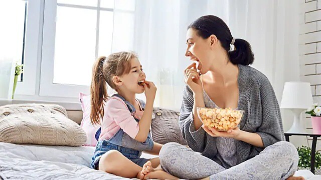 mother and daughter eating popcorn