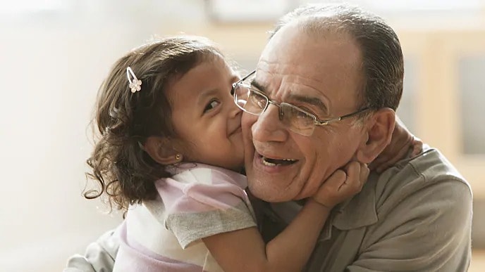 grandfather smiling with granddaughter