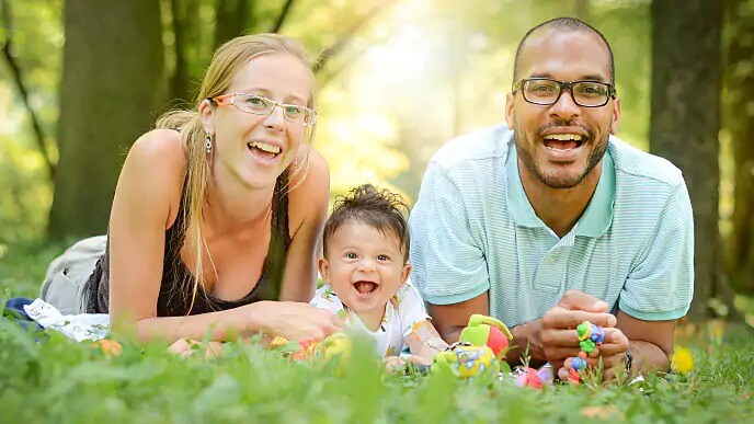 family smiling together outside