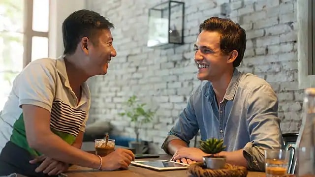Two men smiling during a conversation