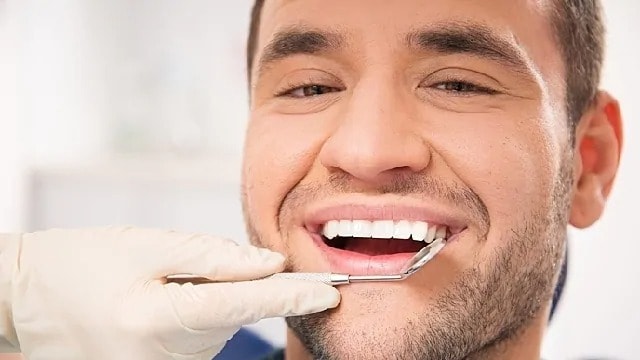Man with white teeth smiling during a dentist's appointment