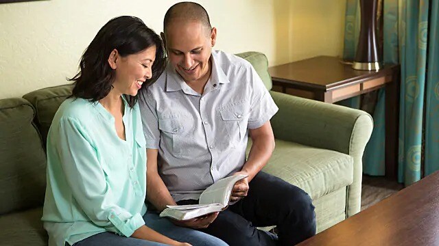 A smiling couple looking at a book