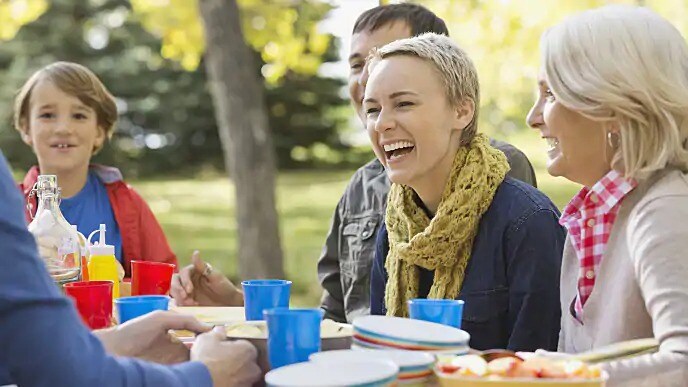 Group of people smiling while seated at a table outside