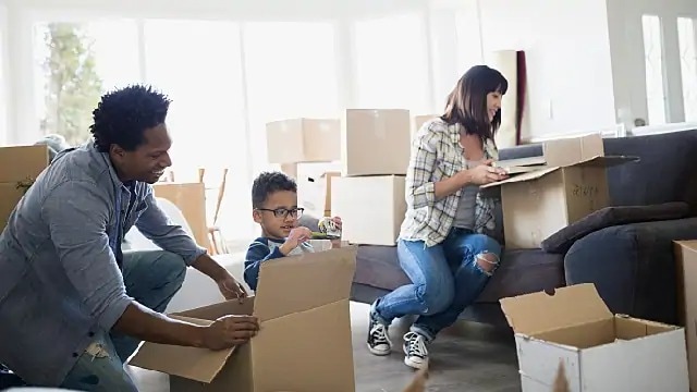 Family of 3 looking into moving boxes