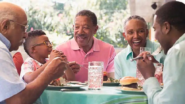 A group of people smiling while seated for a meal