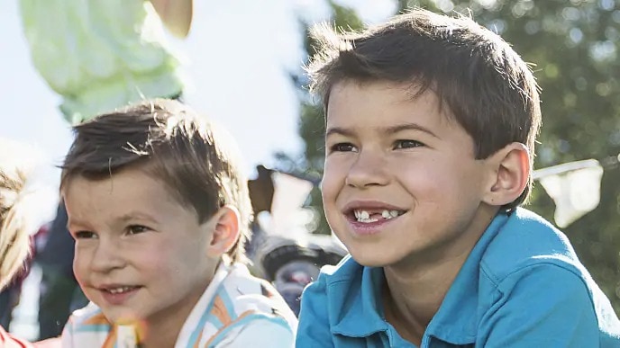 Two boys, one missing a tooth, smiling