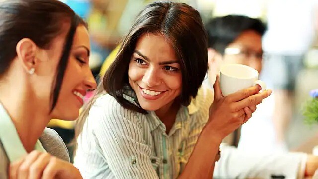 A smiling woman holding a mug