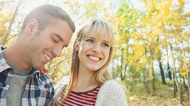 A man and smiling in front of trees