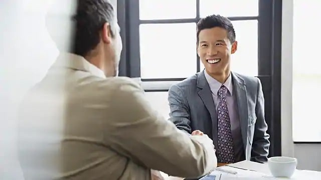 A man smiling while shaking hands