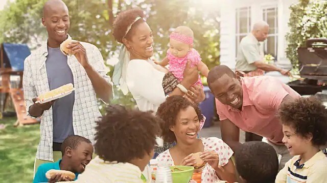 A group of people smiling and laughing at a barbecue