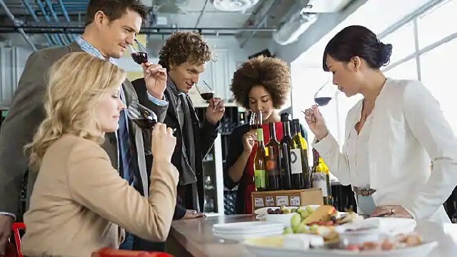 A group of people inhaling wine aroma from glasses A group of people inhaling wine aroma from glasses