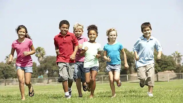 A group of children running on grass