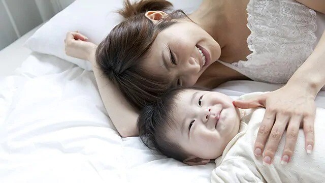 mother getting infant to smile