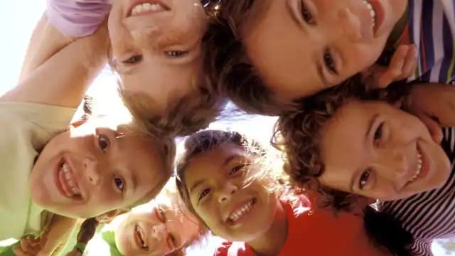 Six children smiling and looking down at the camera