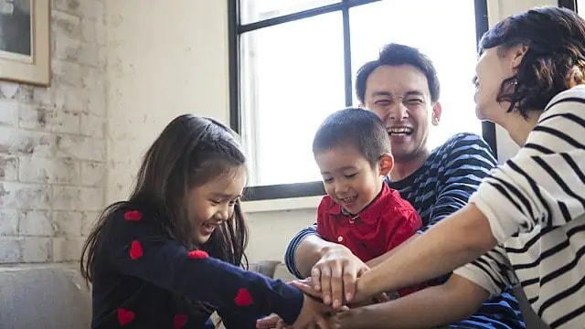 A man and 2 young children all smiling