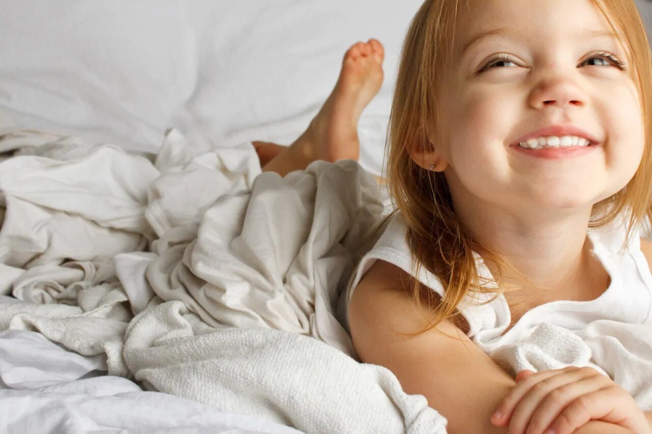 Toddler with pegged teeth lying on their stomach