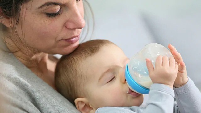 Woman feeding an infant a bottle