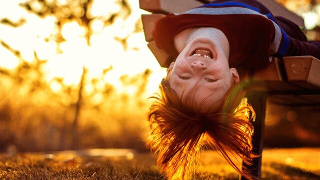 Young child missing a tooth hanging upside down